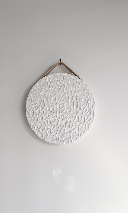 Minimalist round white textured art piece with organic leaf-inspired patterns, hanging on a neutral wall with soft natural light – handmade artwork by Christen Rose.