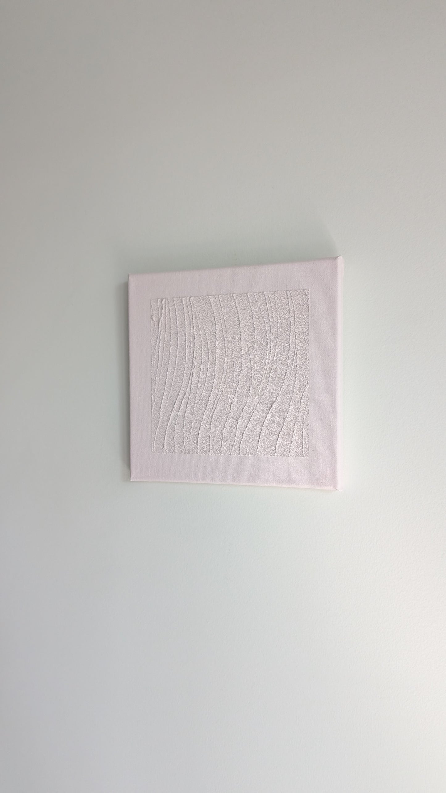 Pink textured square painting on a light gray wall