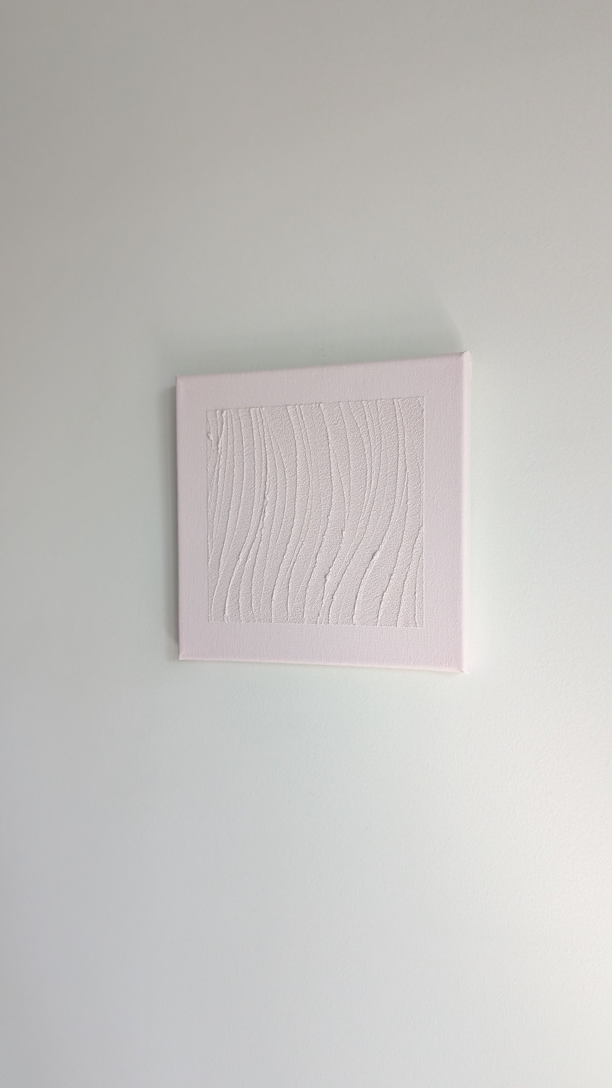 Pink textured square painting on a light gray wall