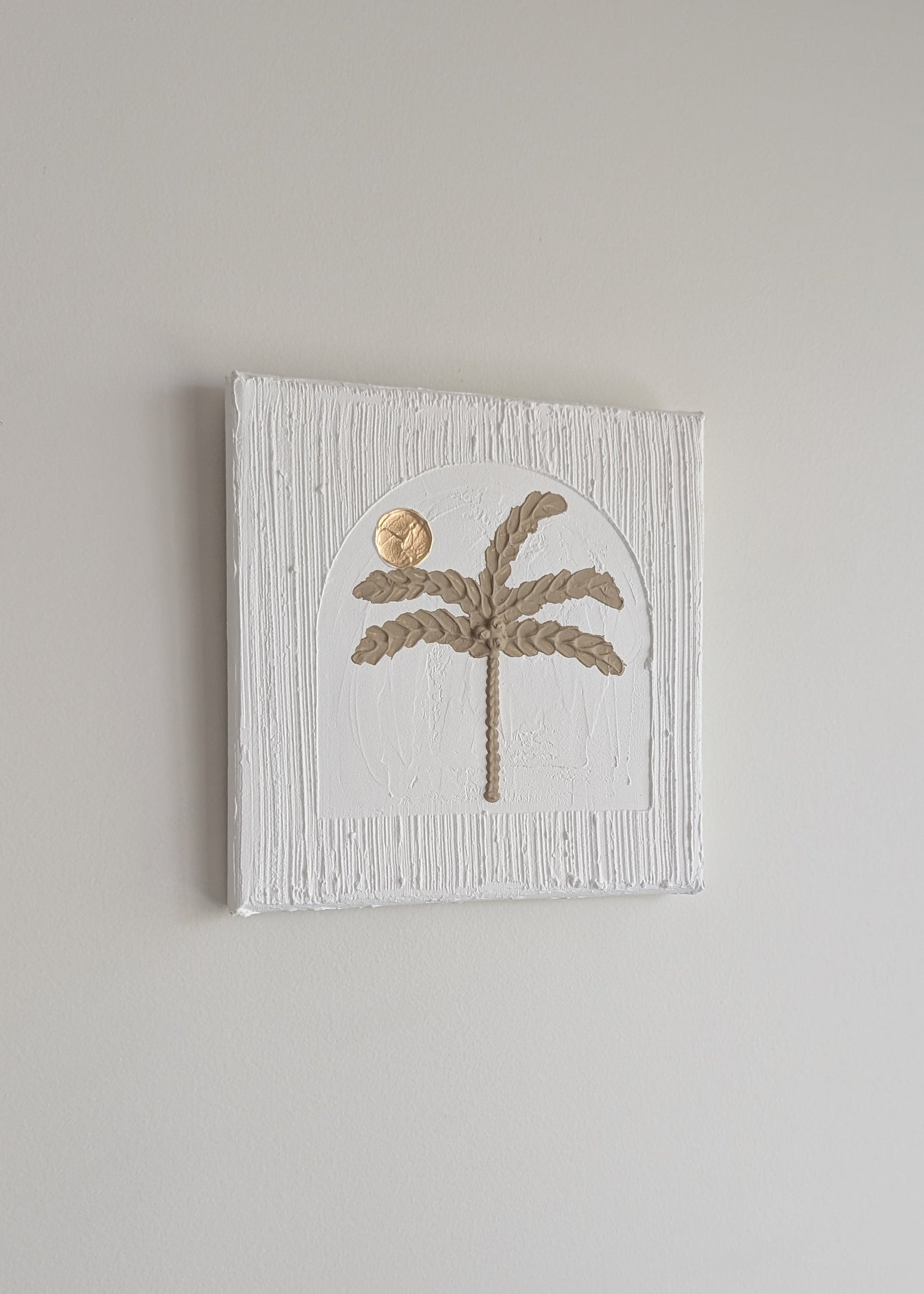 Decorative wall art with palm tree design on a textured white background