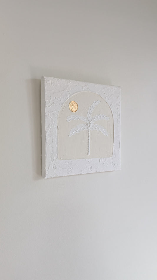 Decorative wall art with palm tree and moon design on a plain wall