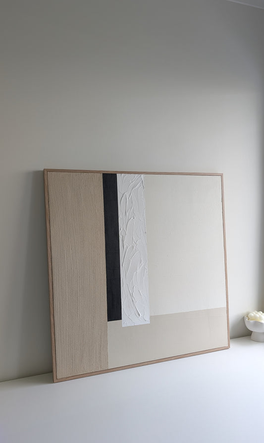 Modern abstract artwork with a wooden frame on a plain wall