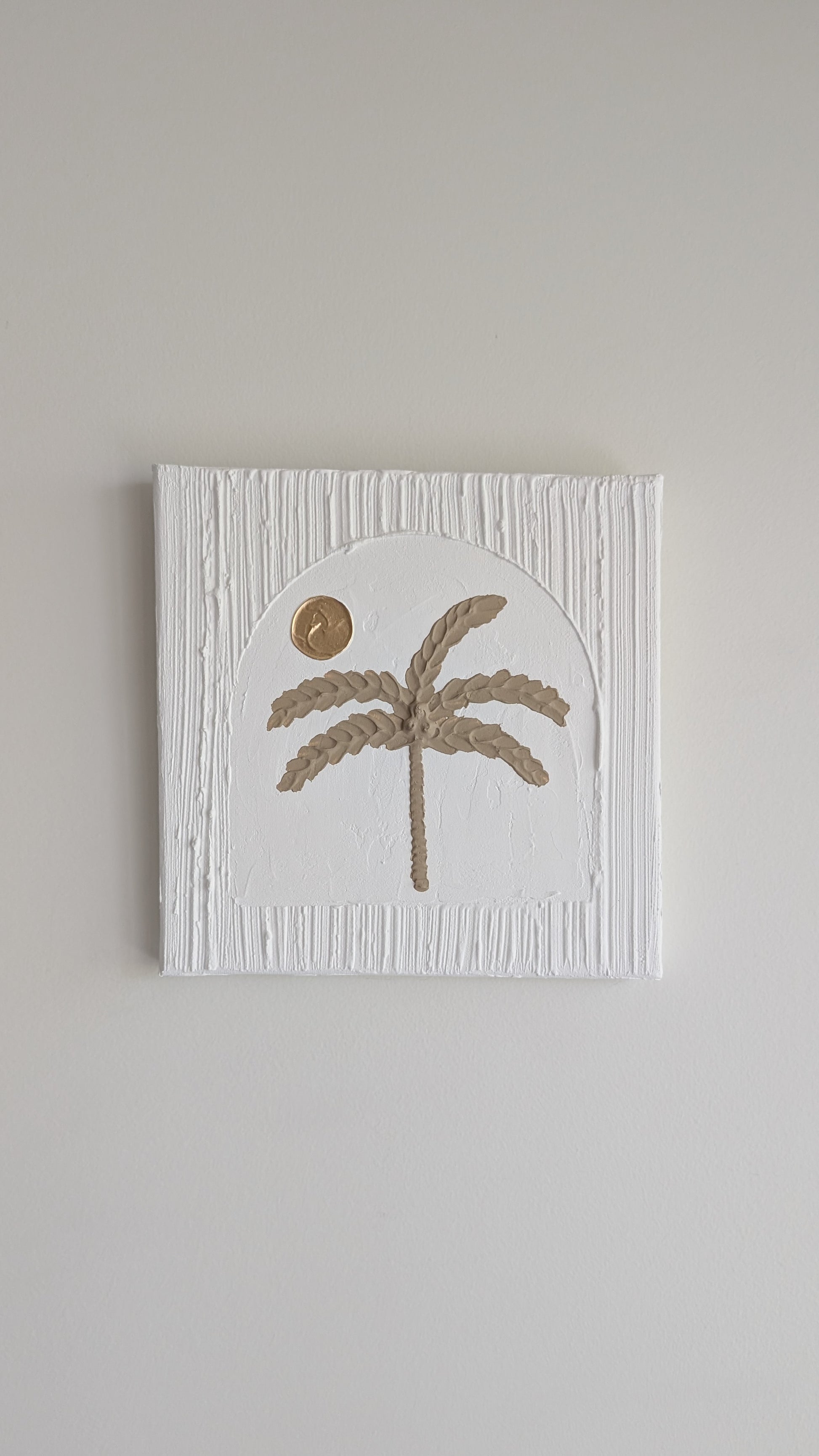 Decorative wall art with a palm tree design on a plain background