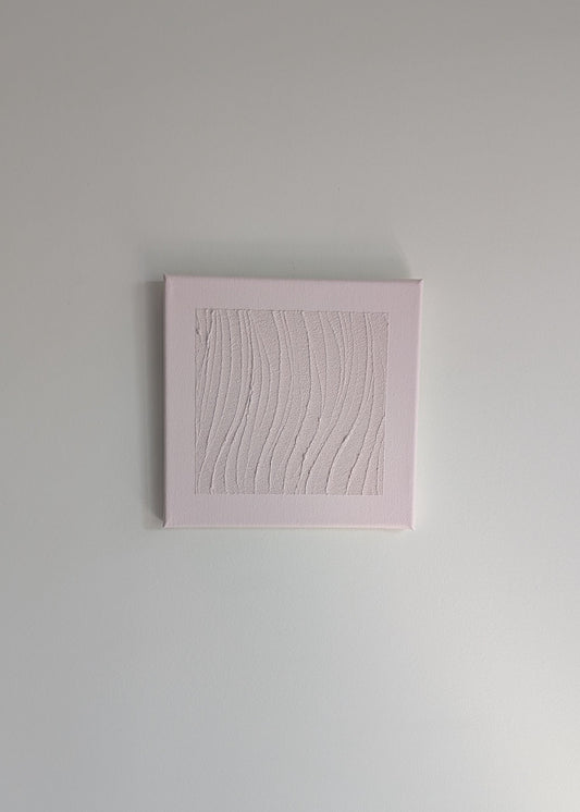 Pink textured square artwork on a light wall background