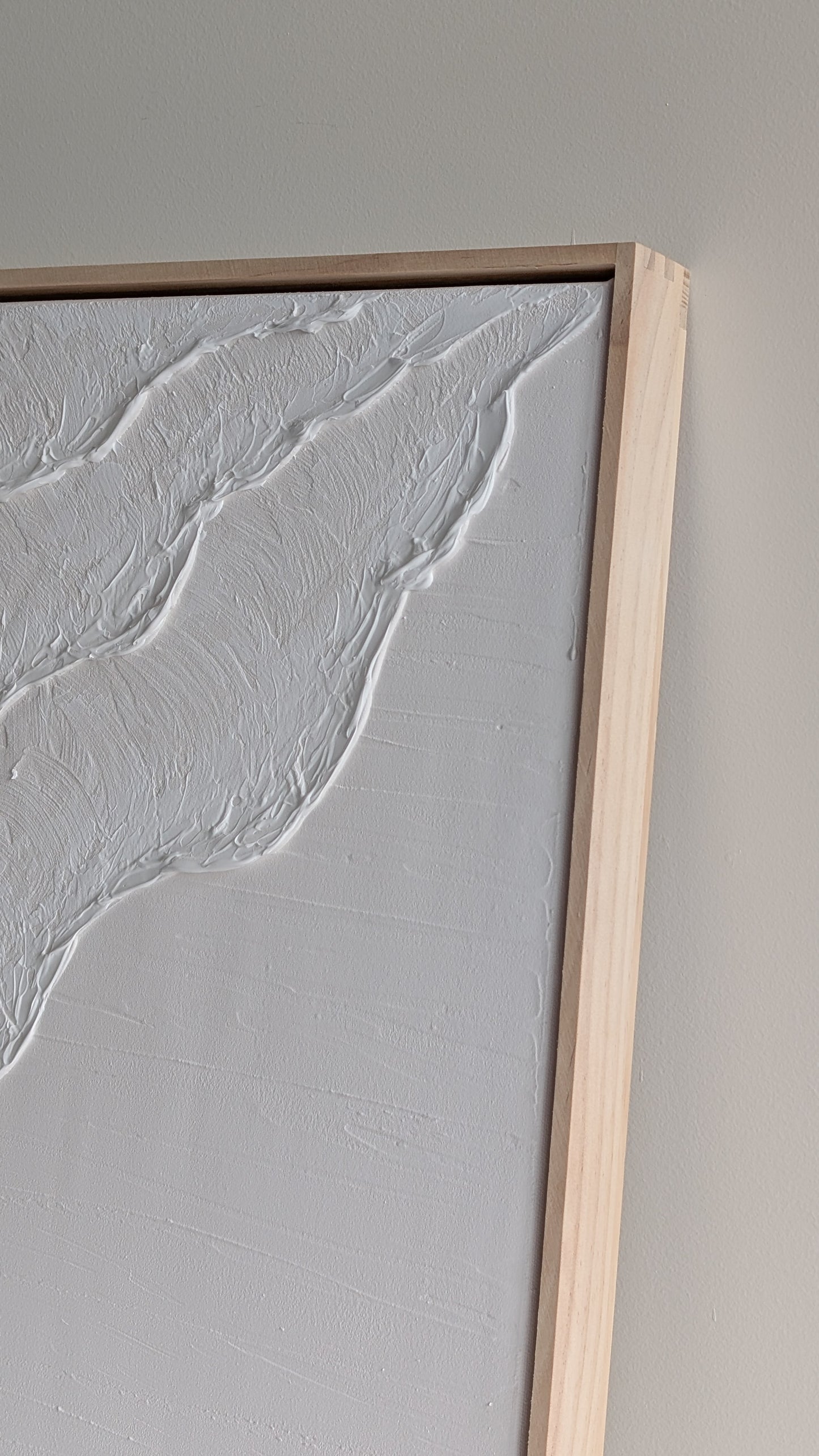 White textured artwork resting on a shelf beside ceramic coastal décor – handmade art by Christen Rose