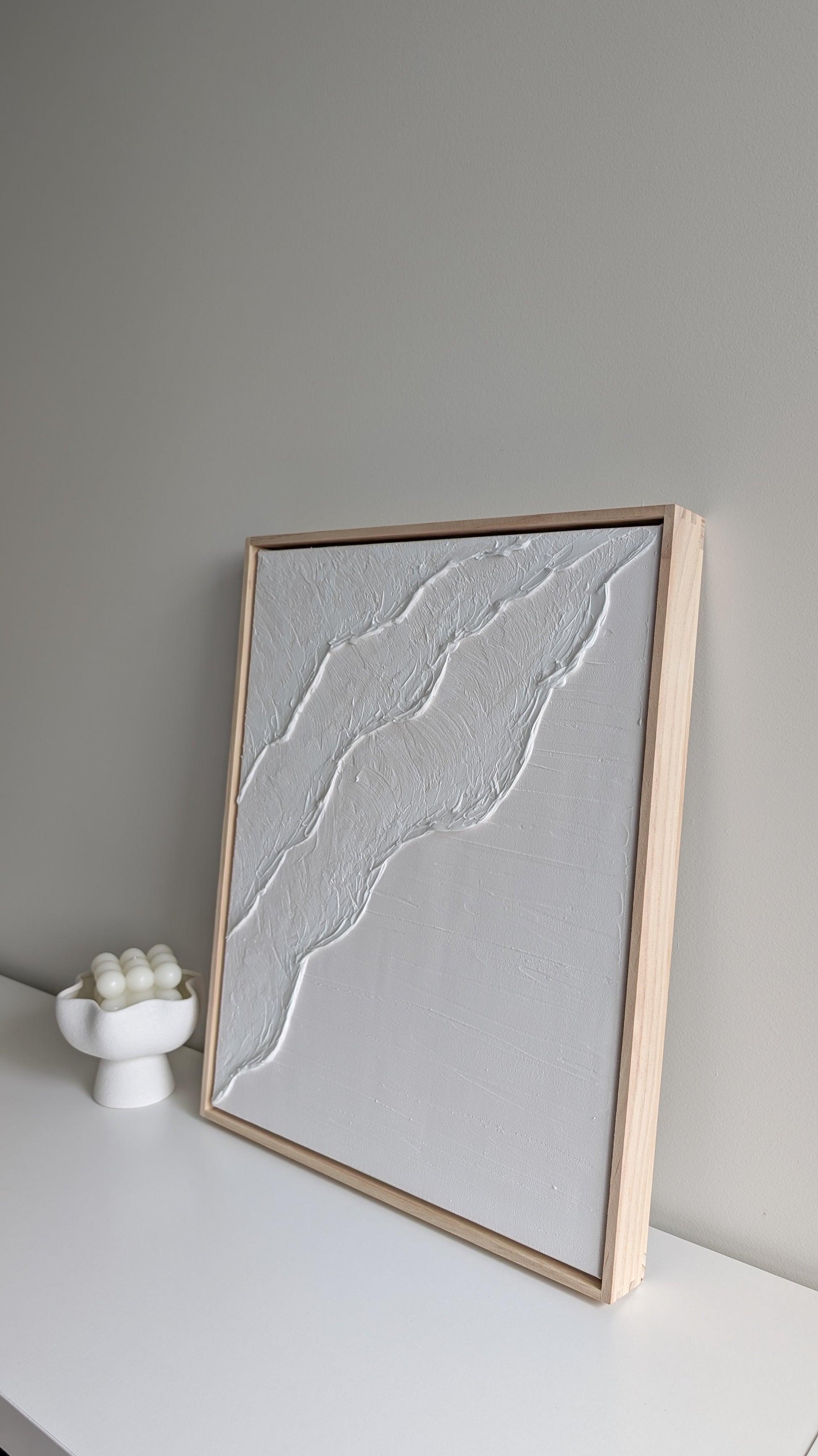 Minimalist coastal wall art framed in natural pine, styled with neutral décor for a serene interior.