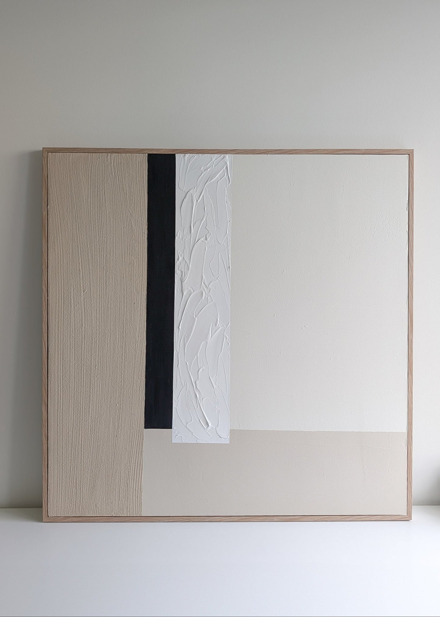 Modern minimalist beige, white and black abstract artwork in a minimalistic setting