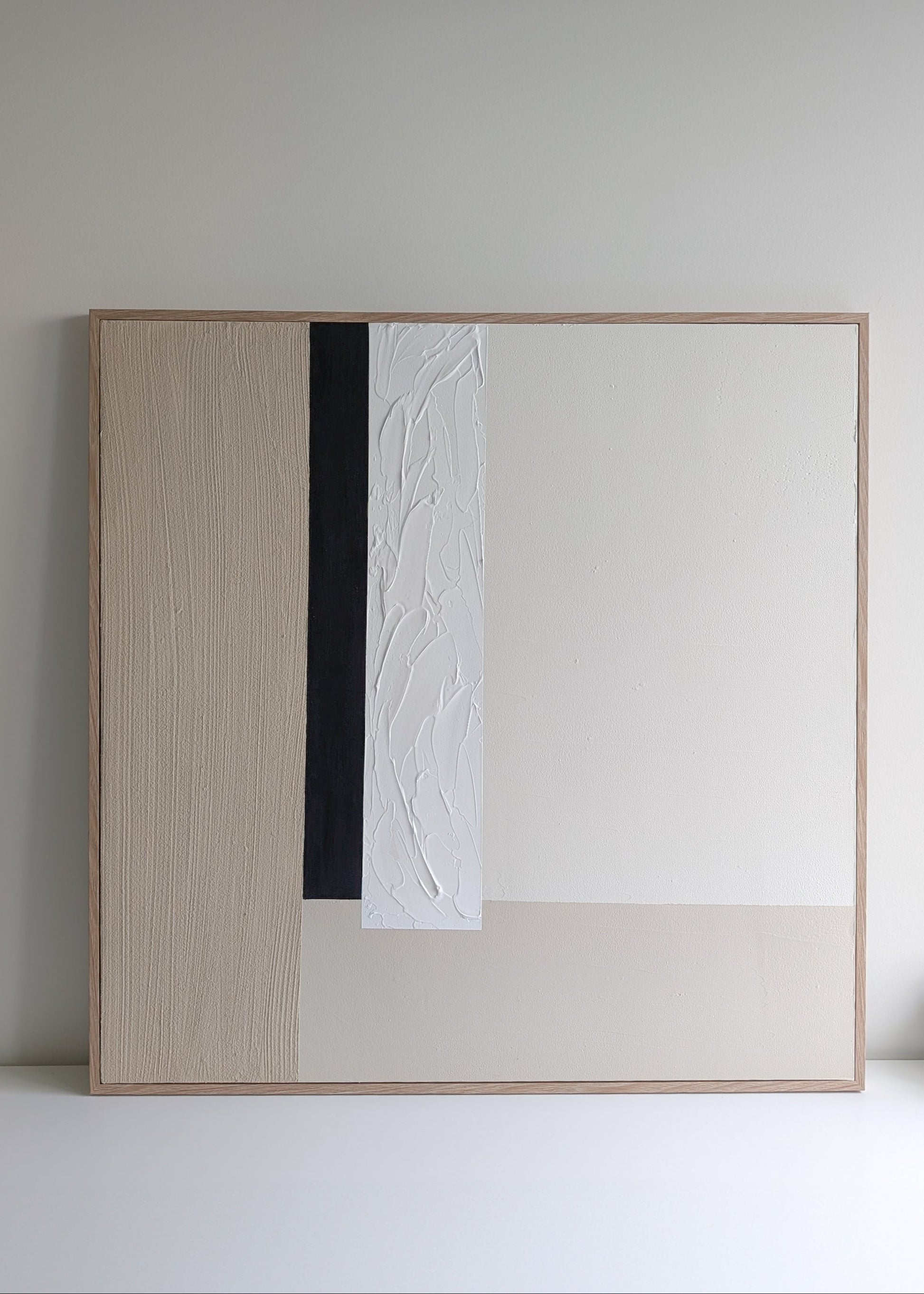 Modern minimalist beige, white and black abstract artwork in a minimalistic setting