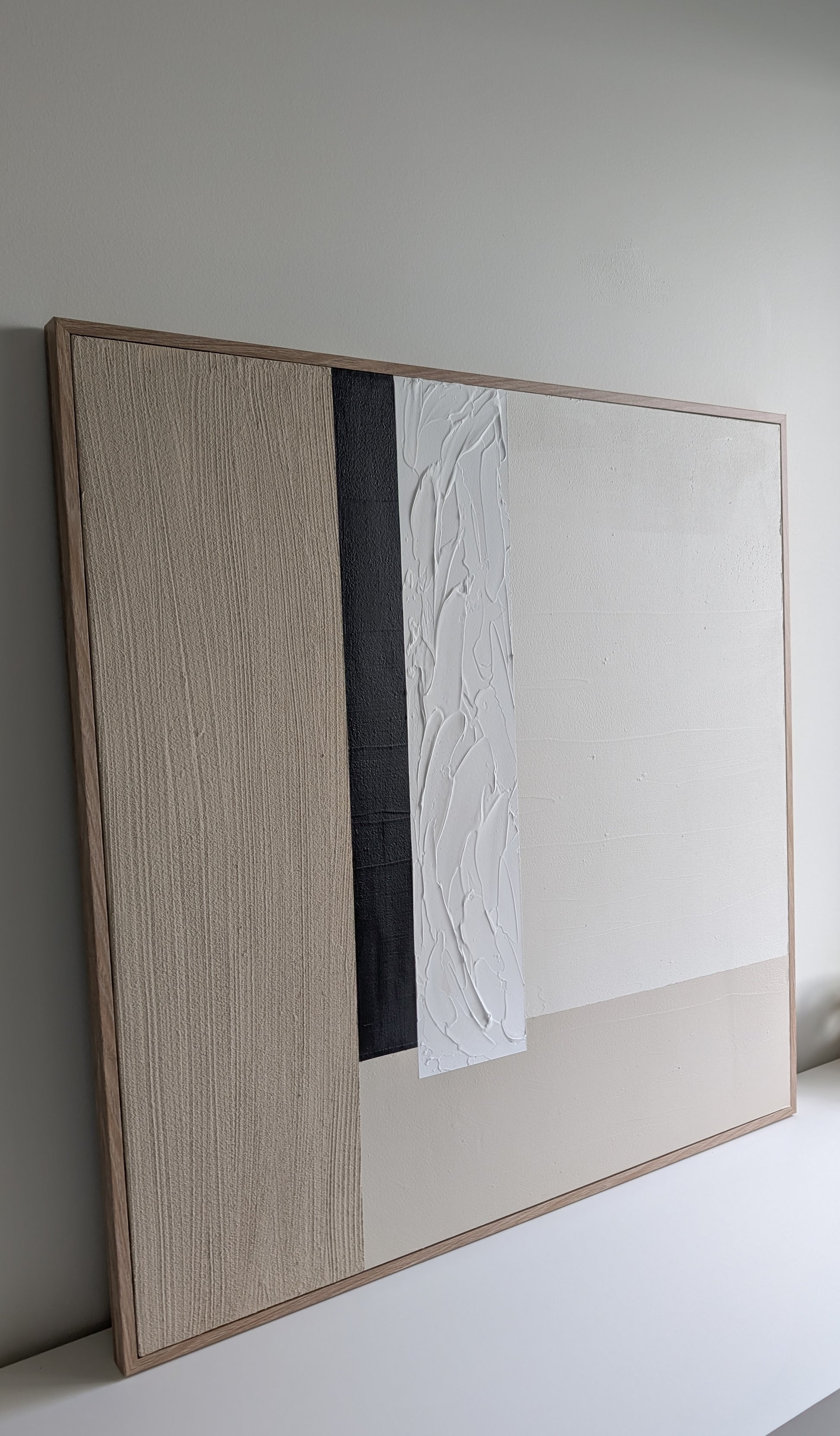 Framed abstract artwork on a white wall