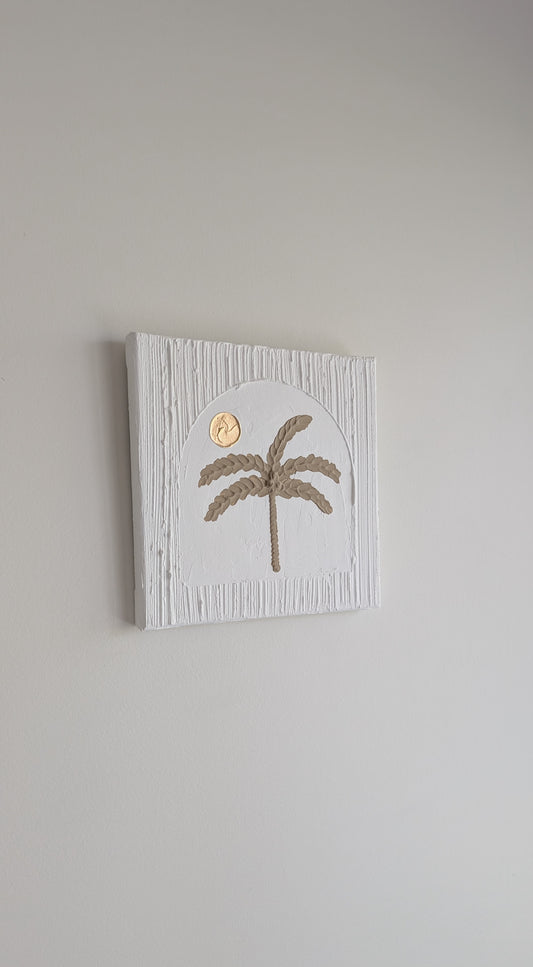 Decorative wall art with a palm tree design on a plain background