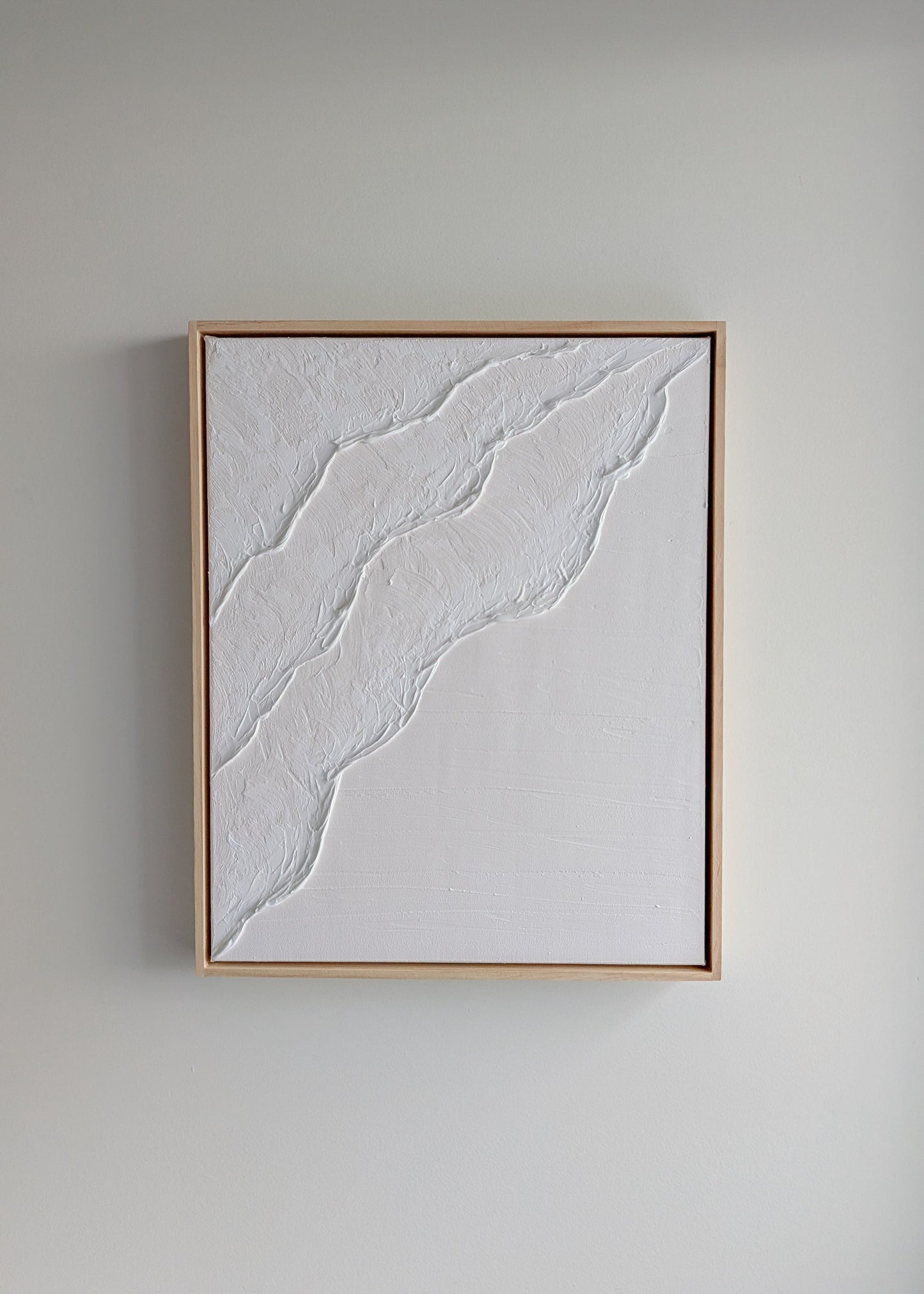 White minimalist textured artwork hanging on a neutral wall, framed in light timber – handmade coastal art by Christen Rose
