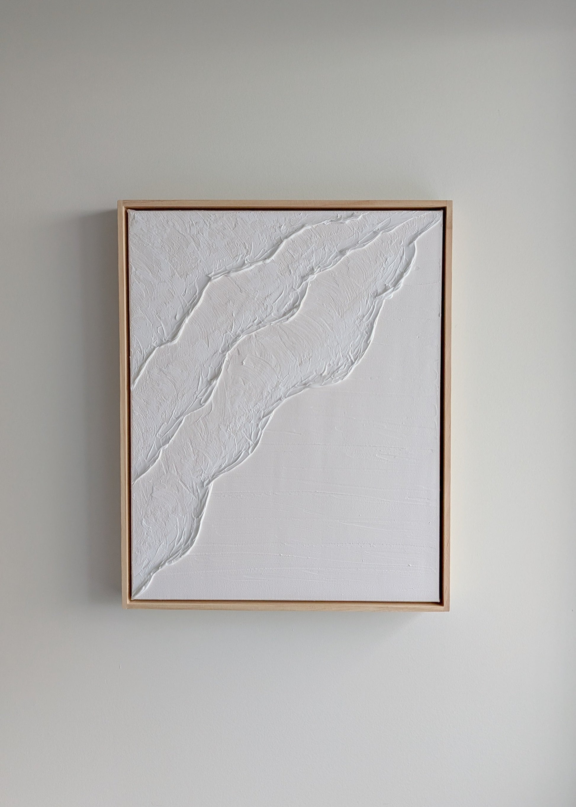 White minimalist textured artwork hanging on a neutral wall, framed in light timber – handmade coastal art by Christen Rose