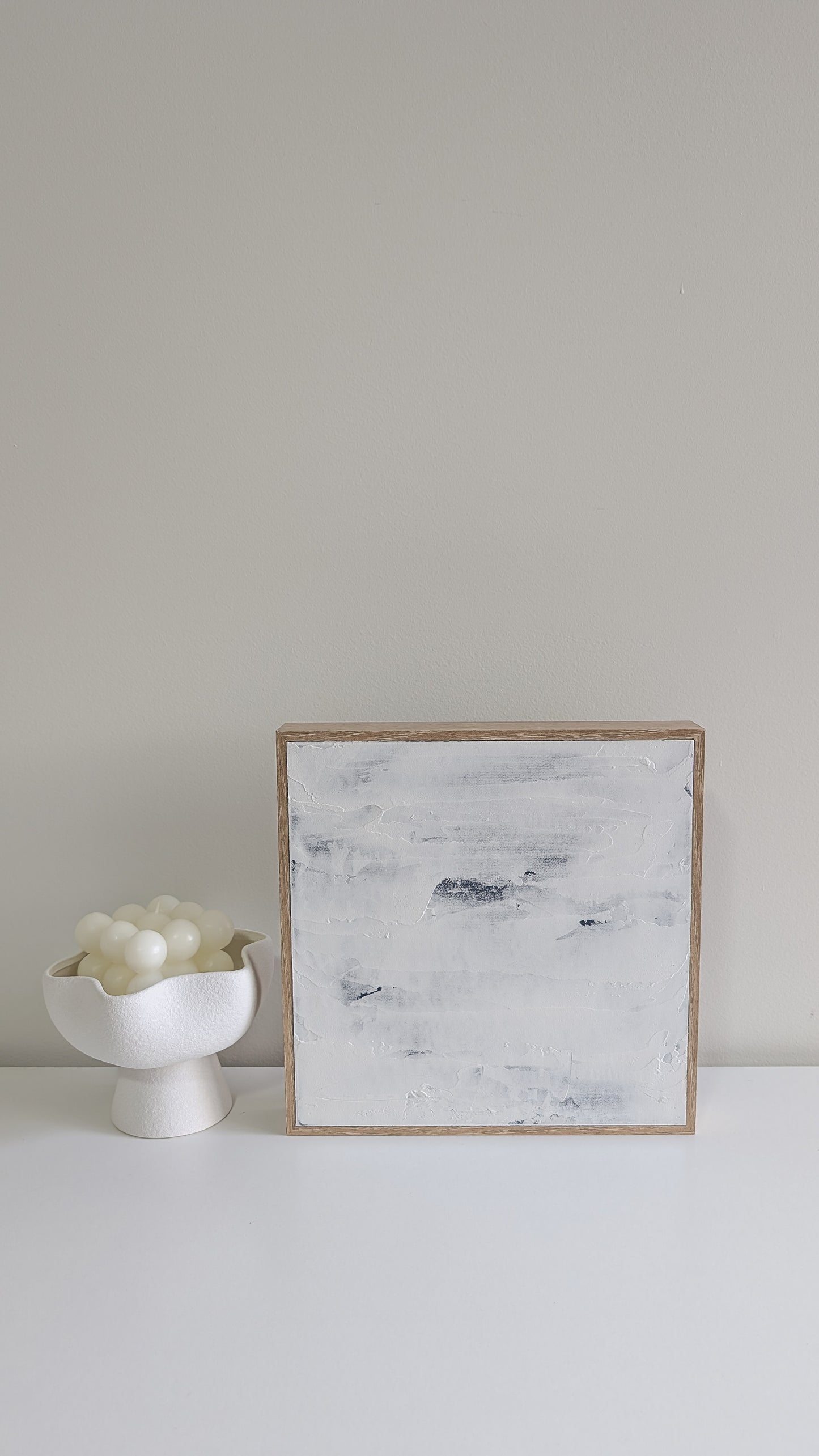 Handcrafted minimalist abstract painting in coastal blue and white, displayed in natural light.
