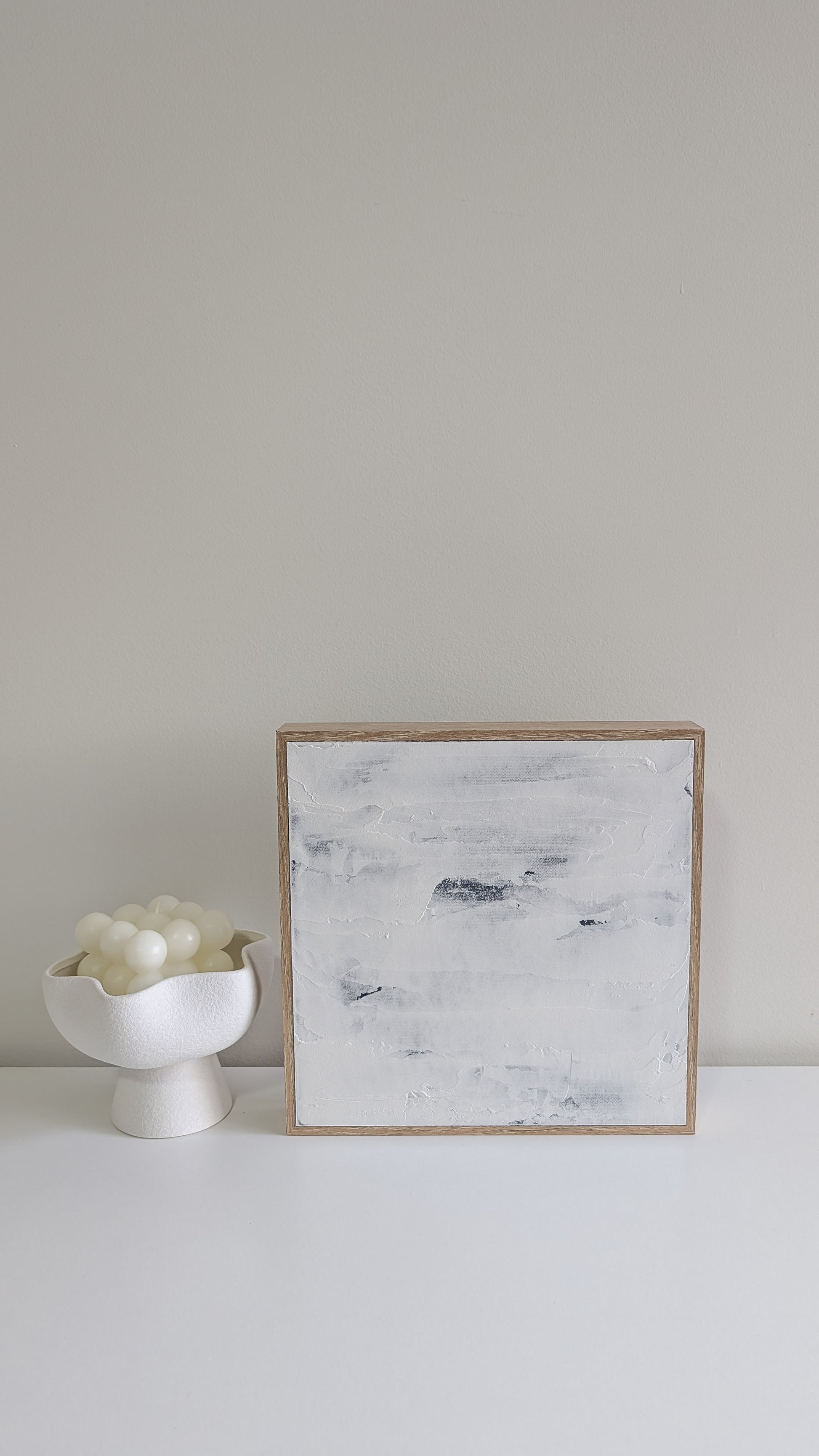 Handcrafted minimalist abstract painting in coastal blue and white, displayed in natural light.